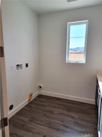 a view of a small space with wooden floor and a window