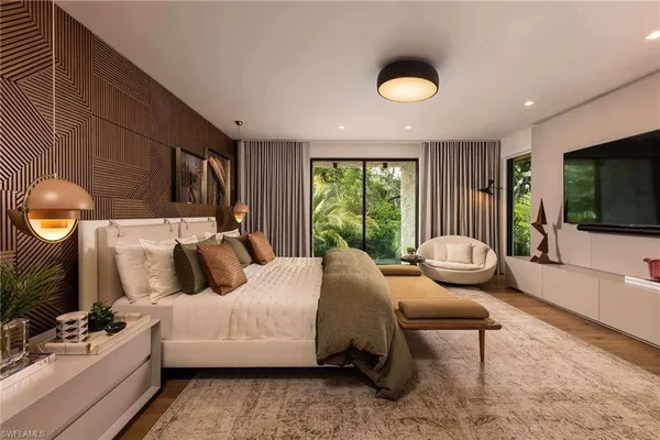 a bedroom with a bed and a chandelier