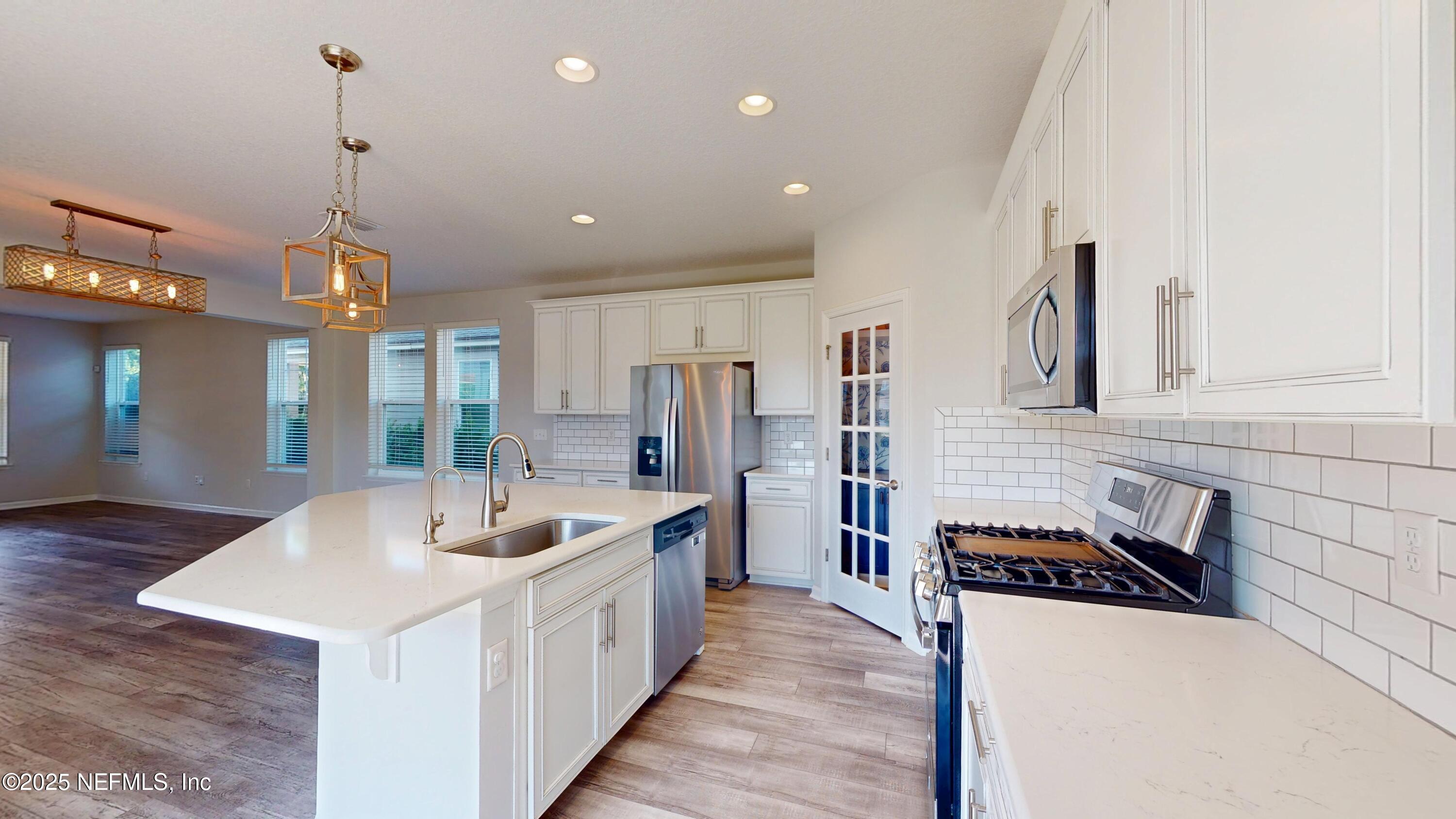 44 Footbridge Road St. Johns, FL 32259 - Photo 18 of 45 a very nice looking kitchen with granite countertop a stove a sink a refrigerator and a dining table with wooden floor