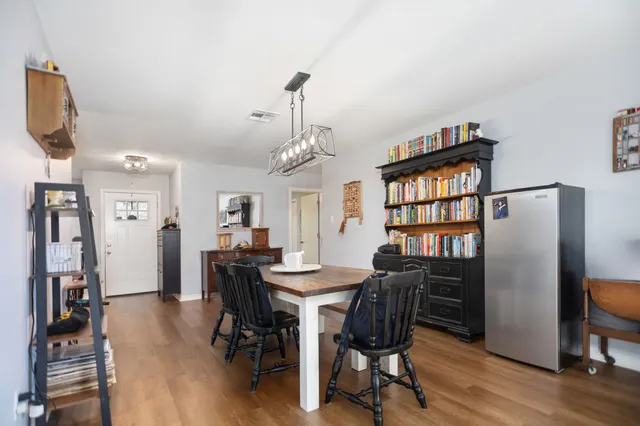 a view of a a dining room with furniture window and wooden floor