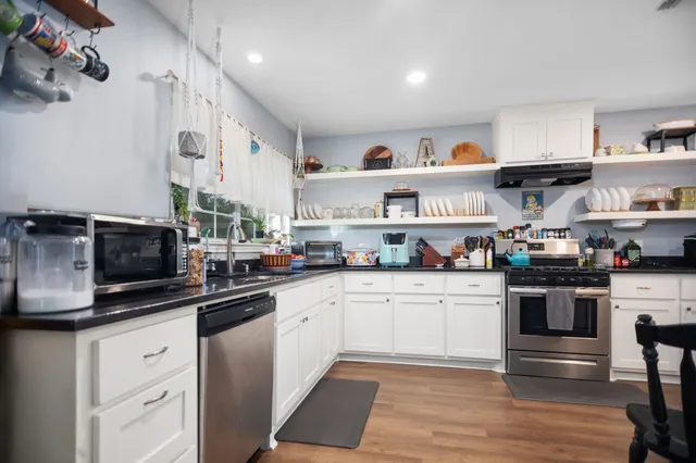 a kitchen with stainless steel appliances granite countertop a sink and stove top oven