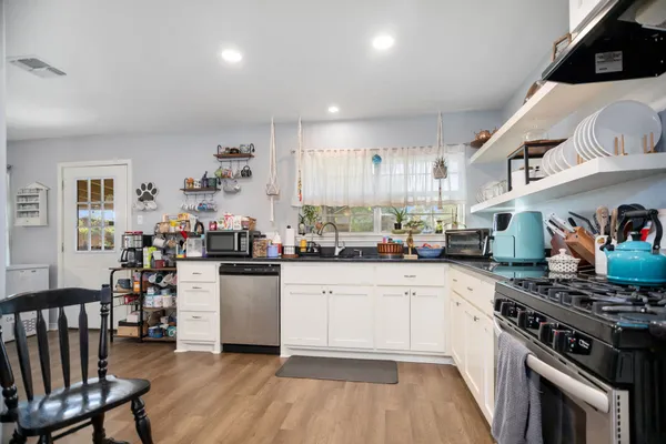 a kitchen with a stove and white cabinets