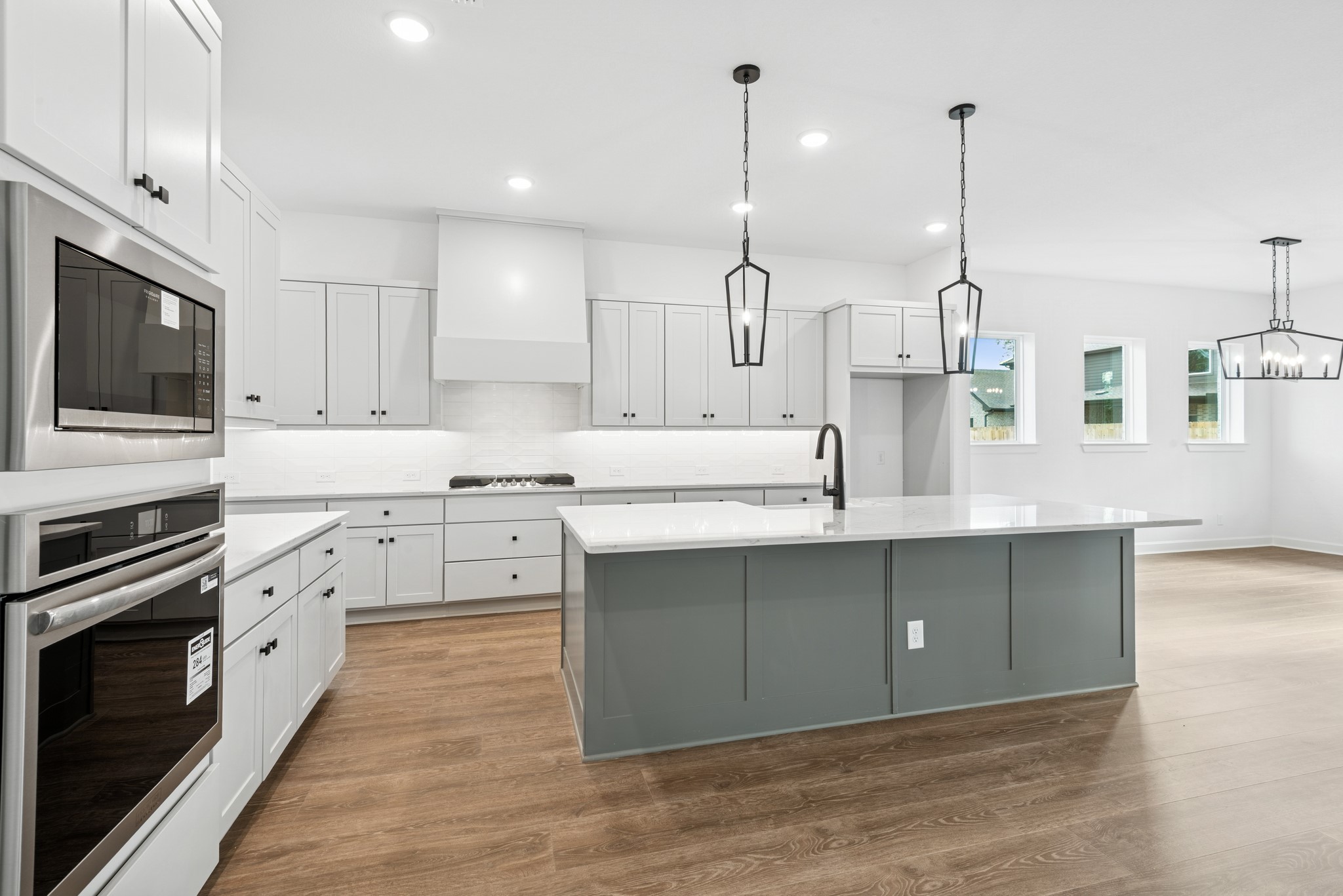 15714 Terracotta Terrace Lane Conroe, TX 77302 - Photo 28 of 47 a kitchen with white cabinets stainless steel appliances and a wooden floor