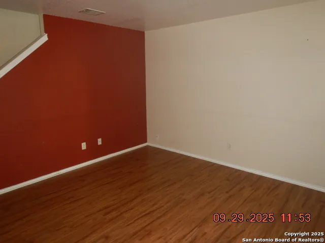 a view of an empty room with wooden floor