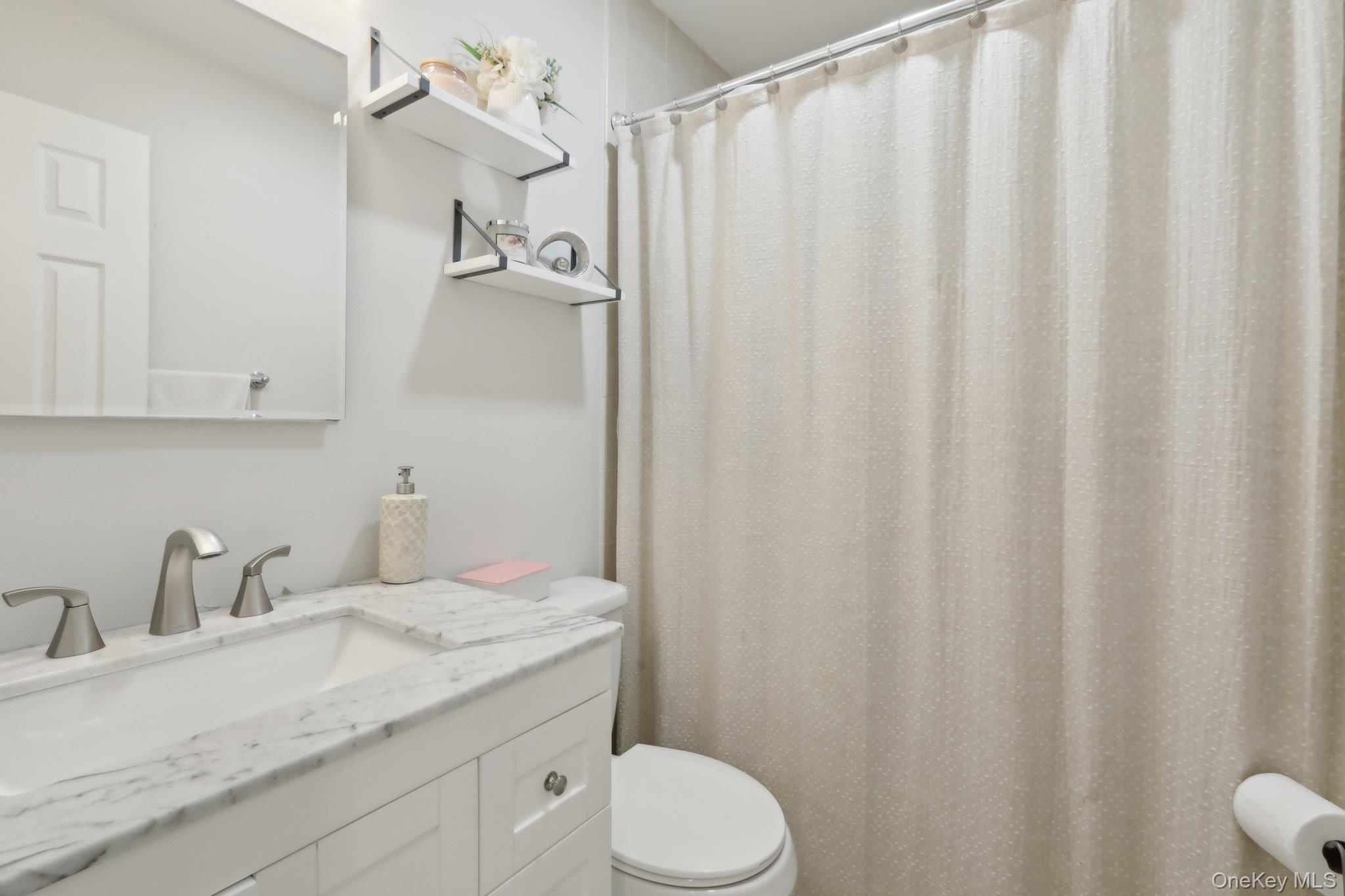 12-14 Lincoln Street Spring Valley, NY 10977 - Photo 22 of 39 Bathroom with toilet, vanity, and curtained shower