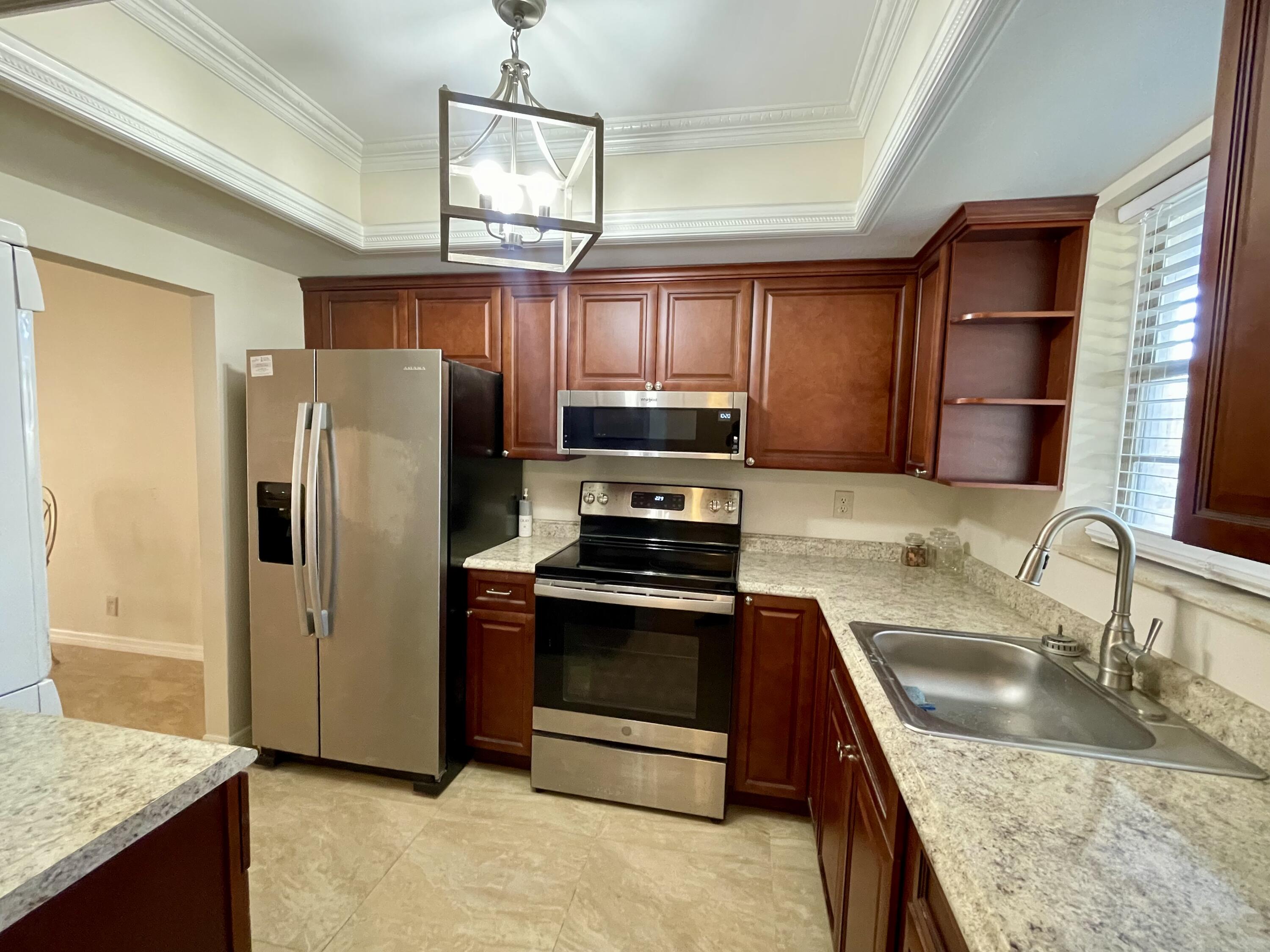 404 Fern Street, Unit 3A Jupiter, FL 33458 - Photo 12 of 12 a kitchen with granite countertop a refrigerator and a sink