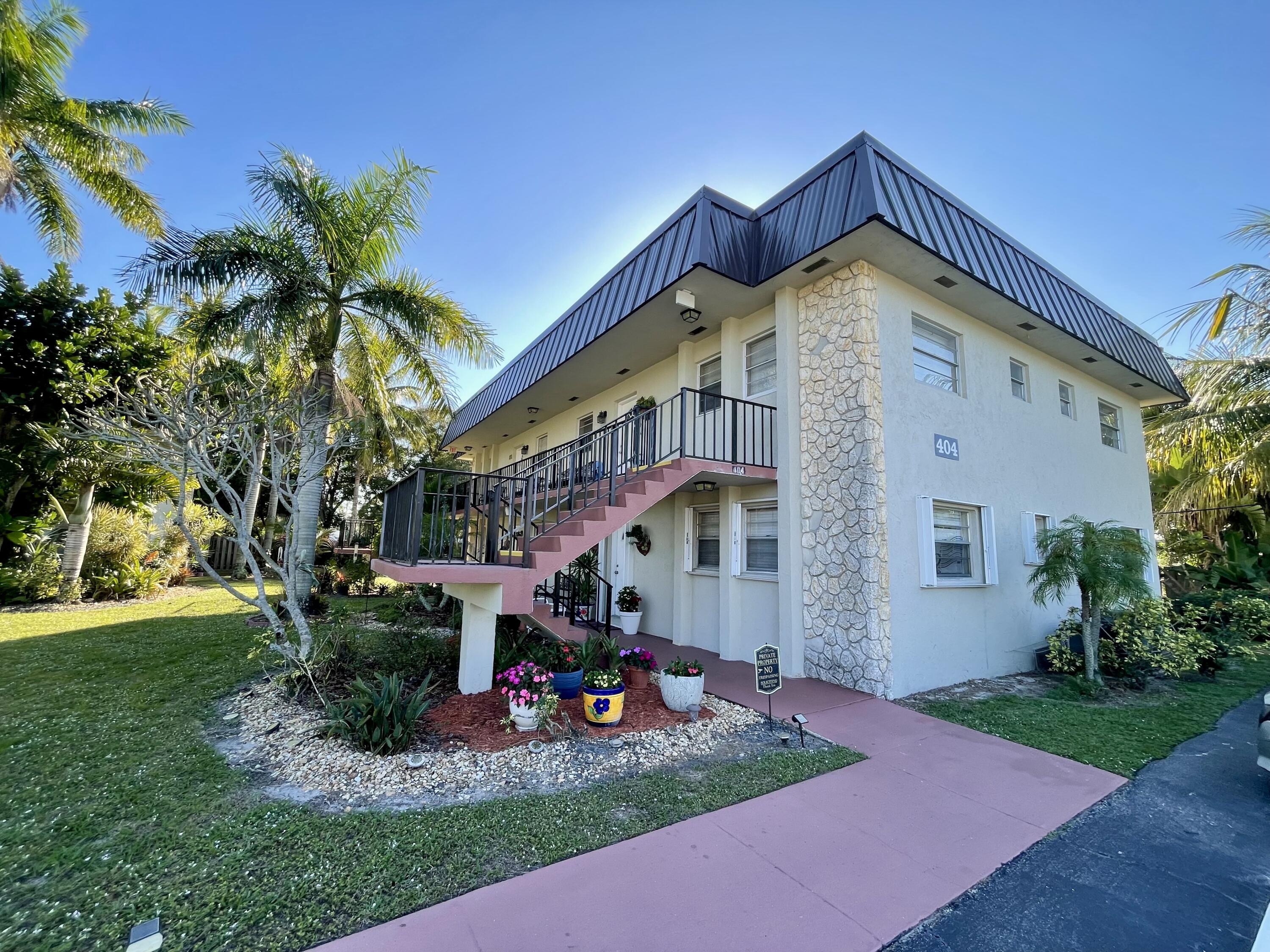 404 Fern Street, Unit 3A Jupiter, FL 33458 - Photo 2 of 12 a front view of a house with garden