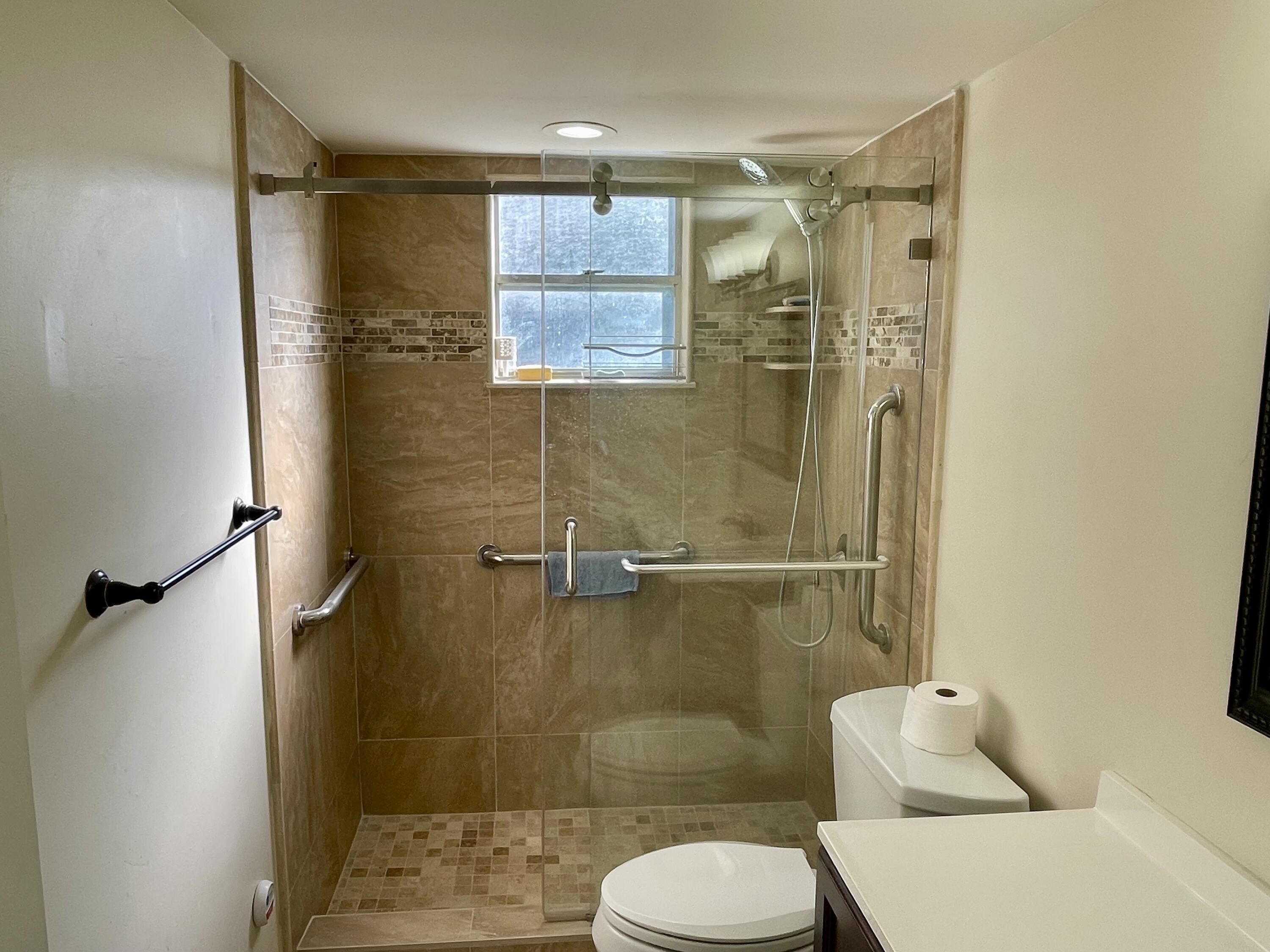 404 Fern Street, Unit 3A Jupiter, FL 33458 - Photo 6 of 12 a bathroom with a shower a toilet and a shower