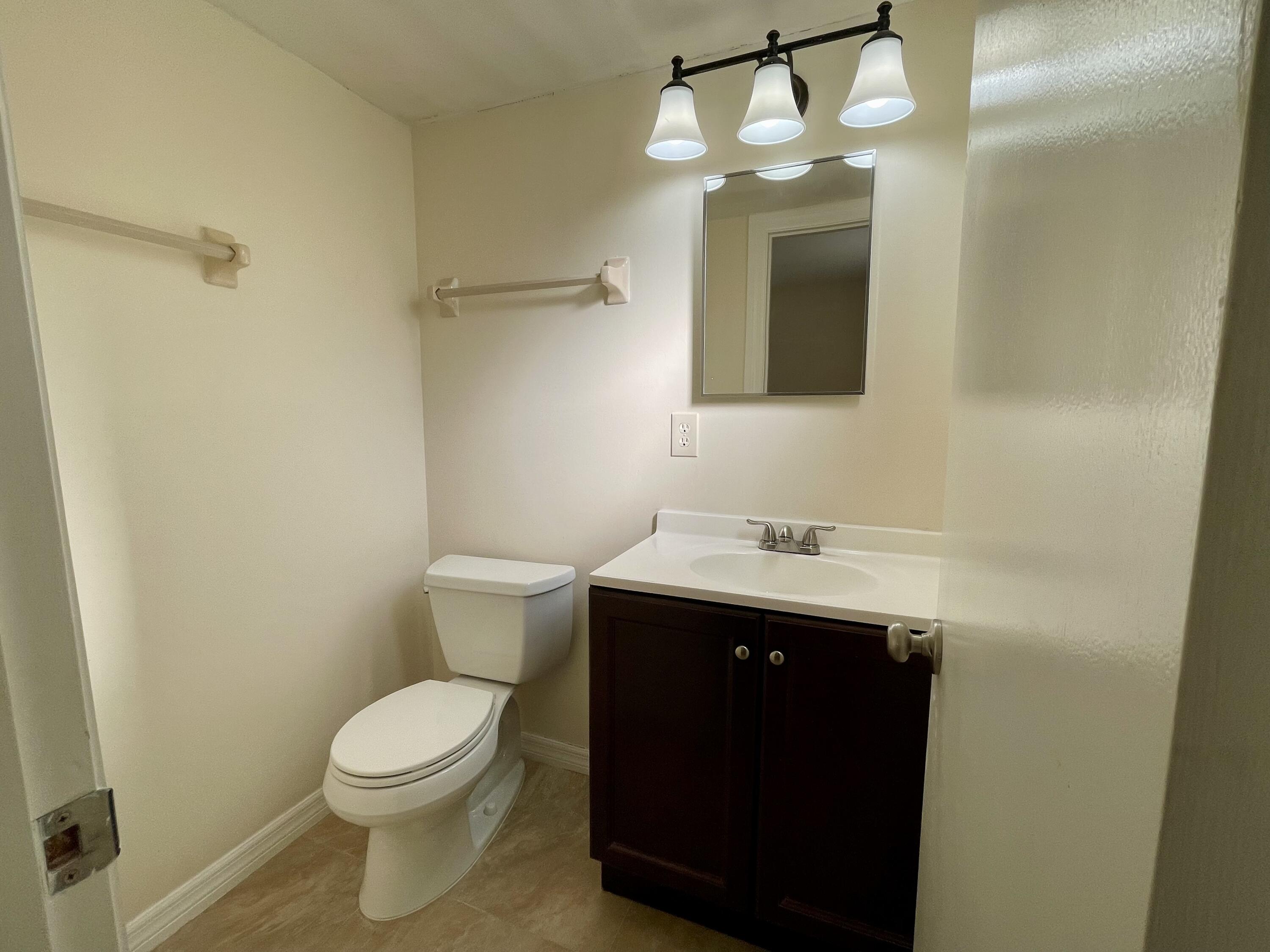 404 Fern Street, Unit 3A Jupiter, FL 33458 - Photo 7 of 12 a bathroom with a sink and a mirror