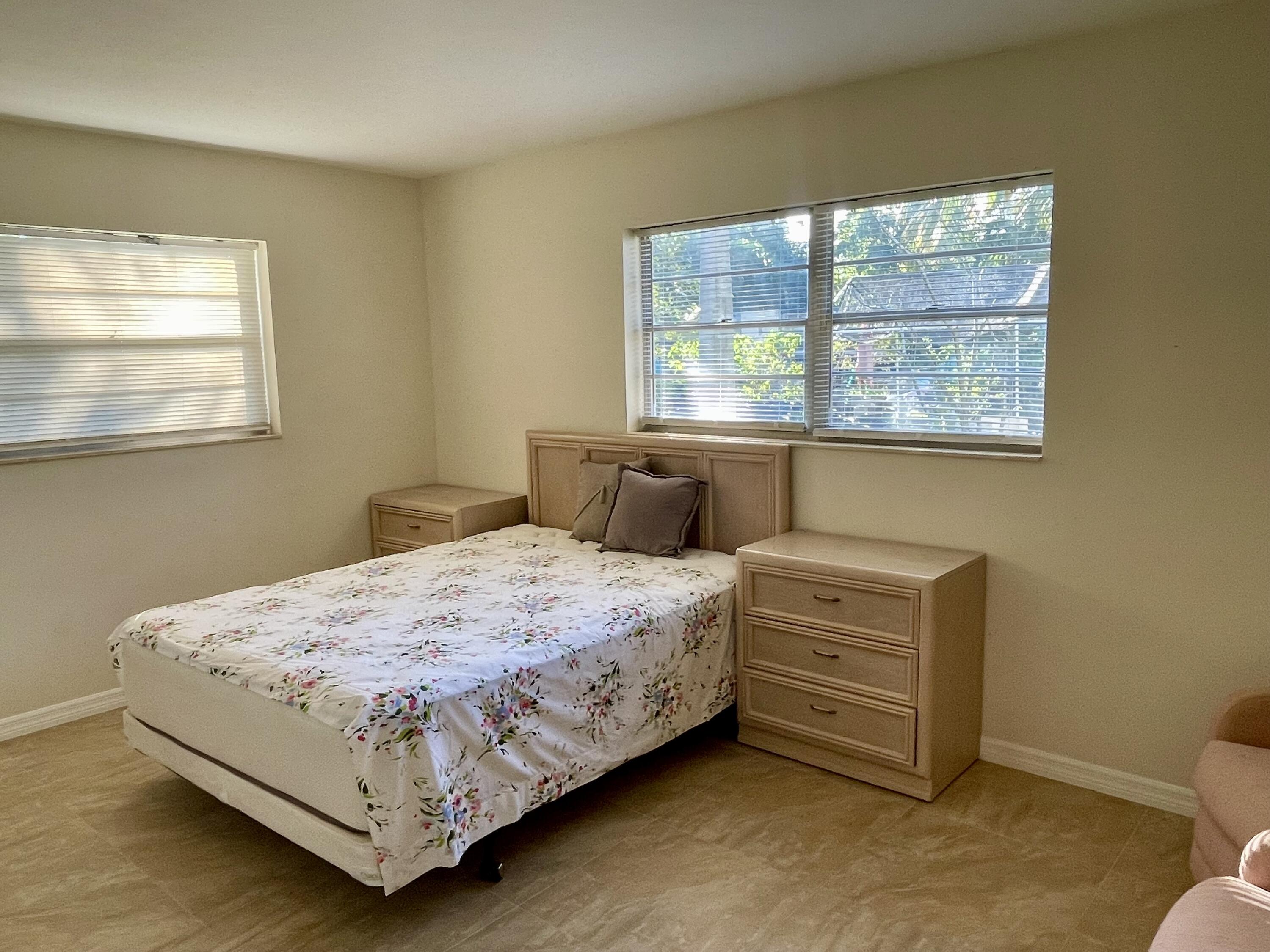 404 Fern Street, Unit 3A Jupiter, FL 33458 - Photo 8 of 12 a bedroom with a bed chair and window
