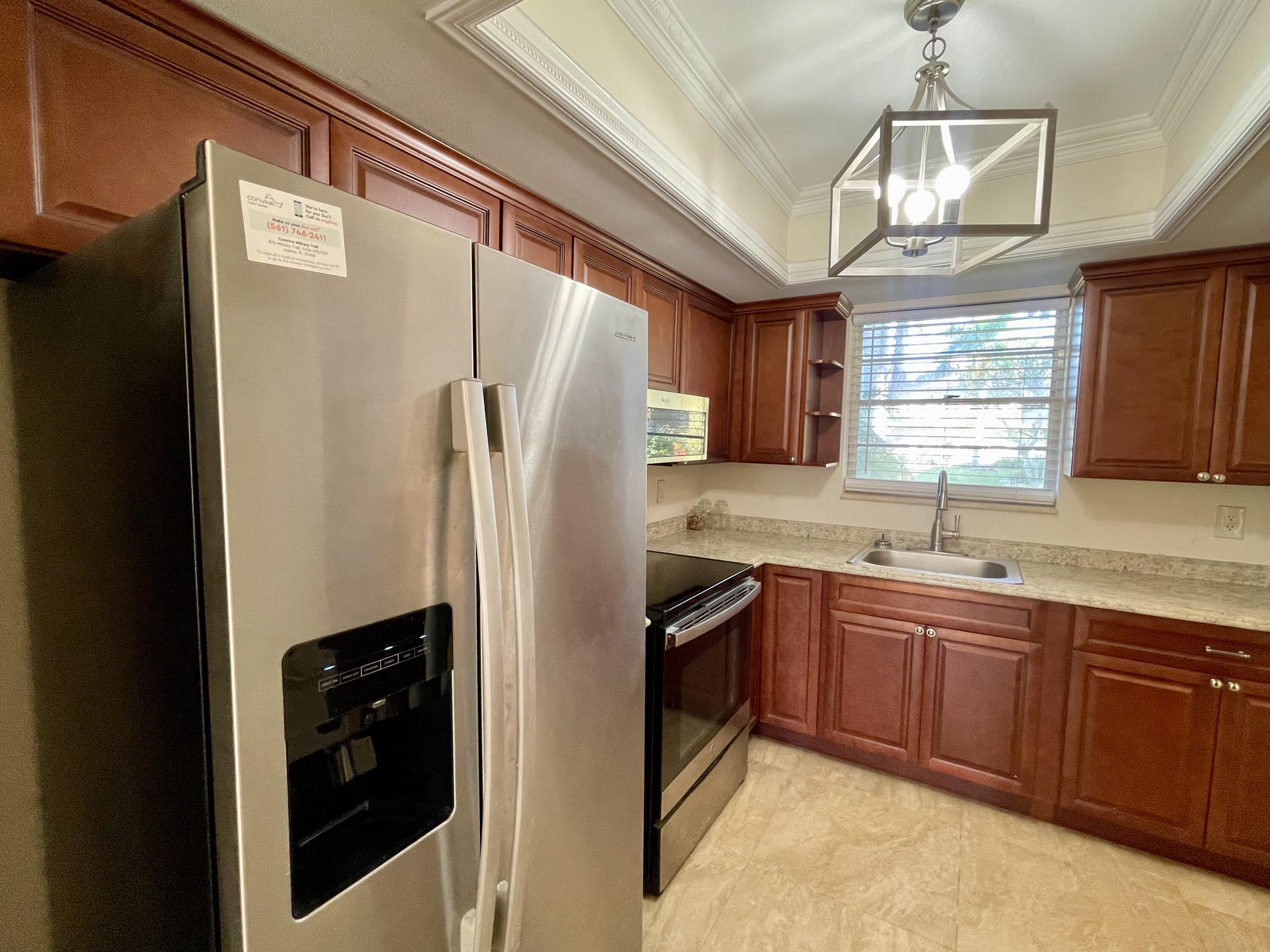 404 Fern Street, Unit 3A Jupiter, FL 33458 - Photo 10 of 12 a kitchen with stainless steel appliances granite countertop a refrigerator a sink a stove and a refrigerator