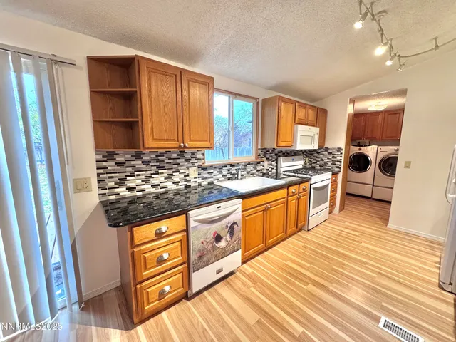a kitchen with stainless steel appliances granite countertop a stove a sink and a refrigerator