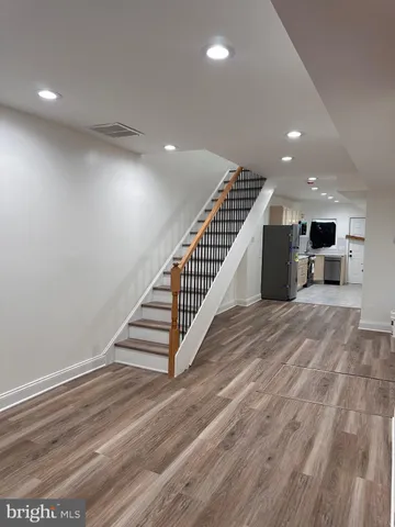 a view of a hall with stairs and wooden floor