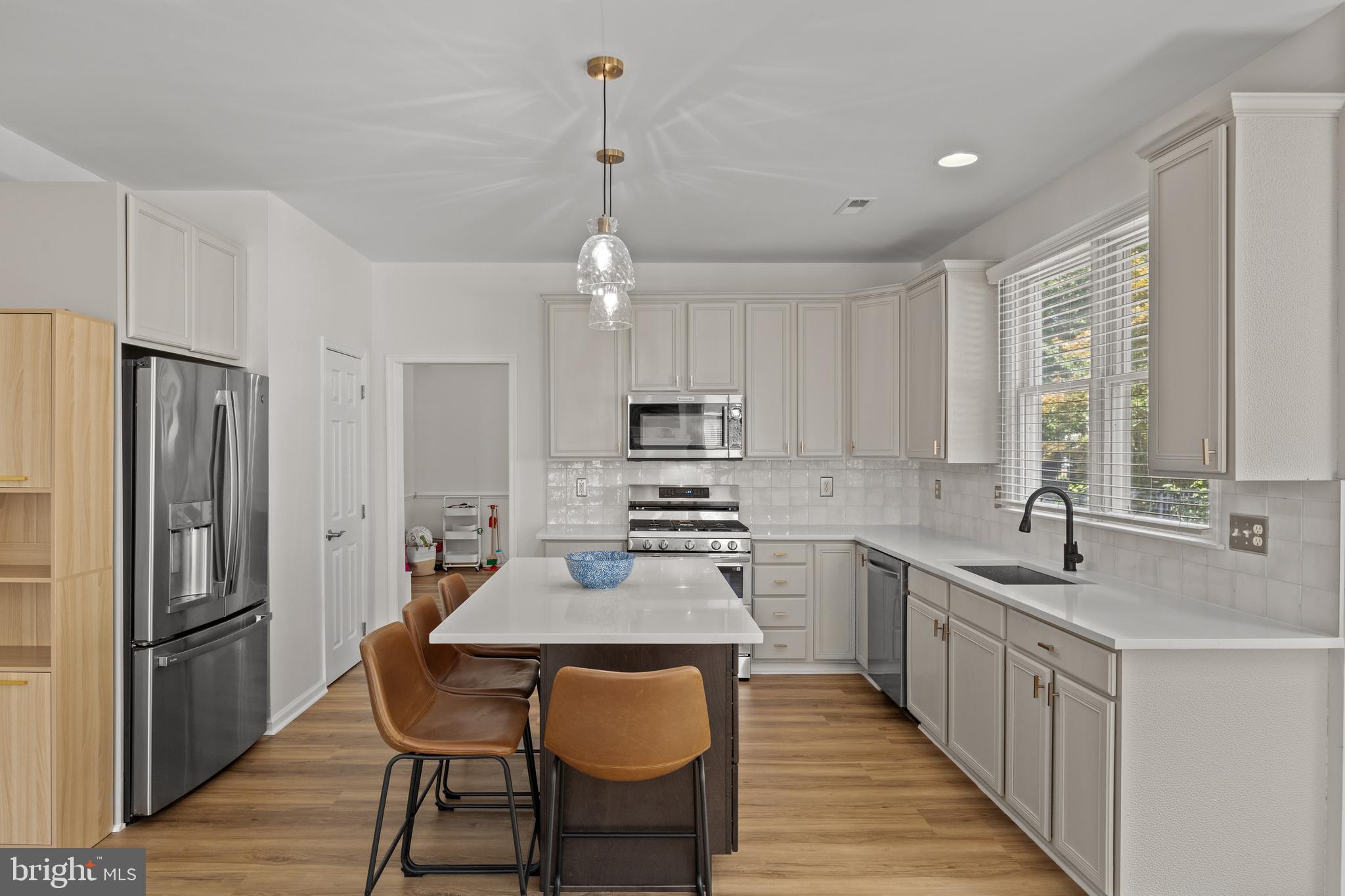 97 Brooks Road Moorestown, NJ 08057 - Photo 14 of 47 a kitchen with a refrigerator a sink dishwasher a stove and white cabinets with wooden floor