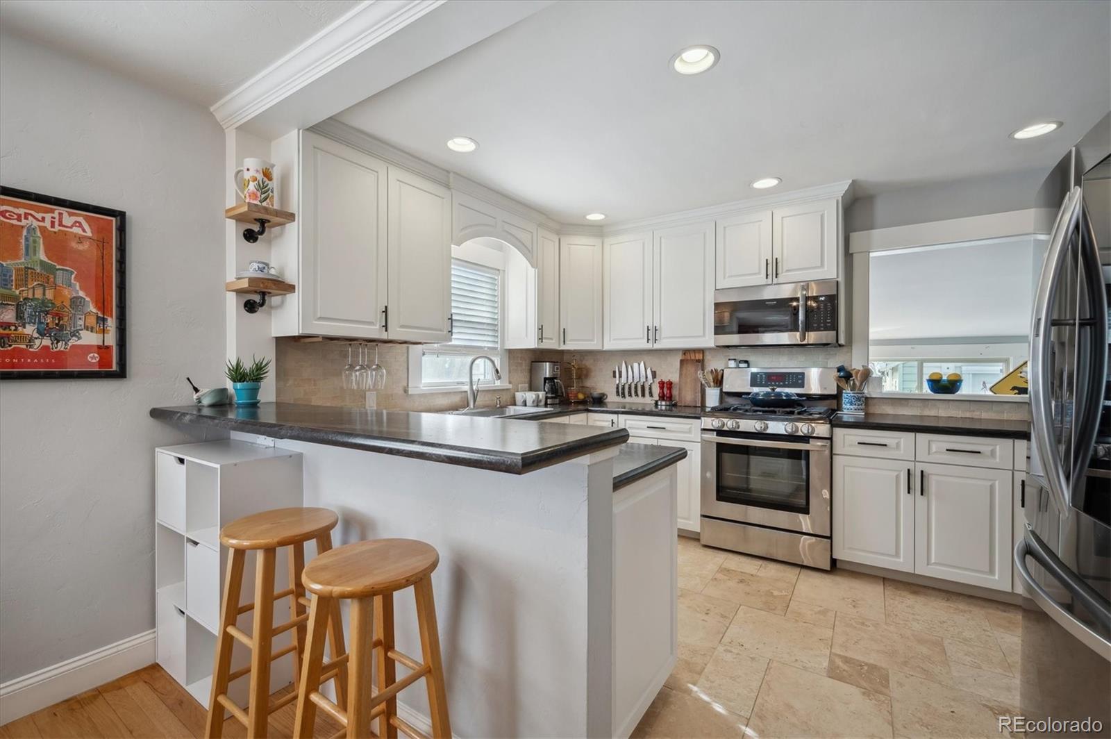 3885 Quay Street Wheat Ridge, CO 80033 - Photo 16 of 40 a kitchen with stainless steel appliances granite countertop a refrigerator sink and stove