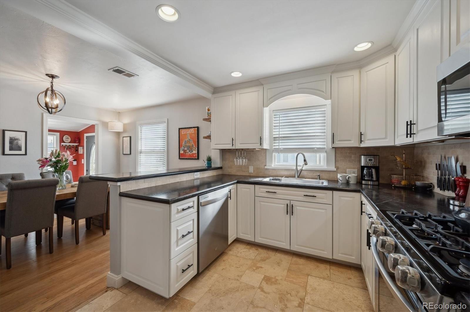3885 Quay Street Wheat Ridge, CO 80033 - Photo 18 of 40 a large kitchen with stainless steel appliances granite countertop a stove and a sink