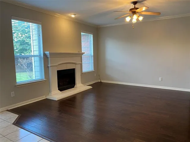a view of a livingroom with a fireplace wooden floor and windows