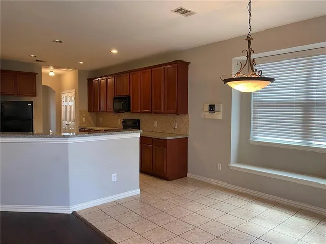 a kitchen with kitchen island granite countertop appliances cabinets and a sink