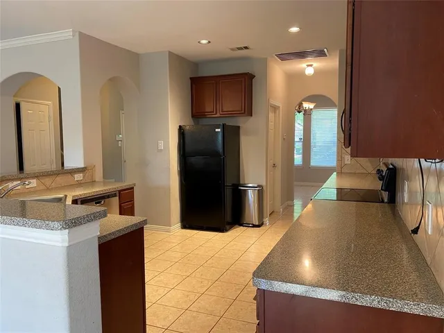 a kitchen with stainless steel appliances granite countertop a refrigerator and a stove