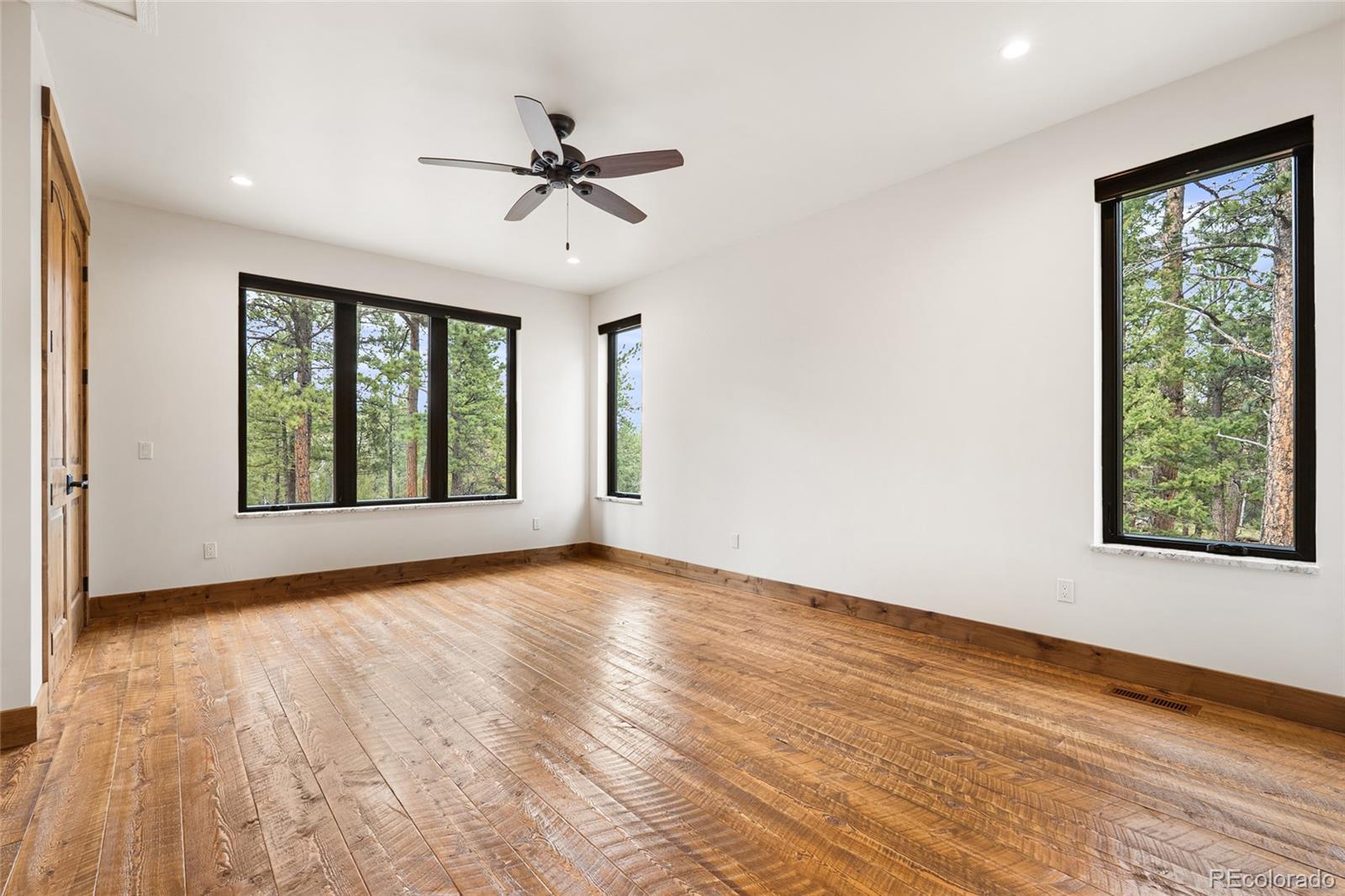 280 Double Tree Road Bailey, CO 80421 - Photo 25 of 43 a view of an empty room with wooden floor and a window
