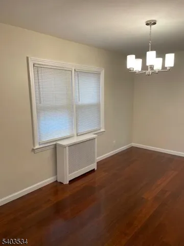 an empty room with wooden floor cabinets and windows