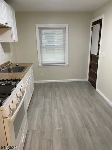 an entryway with wooden floor and cabinets
