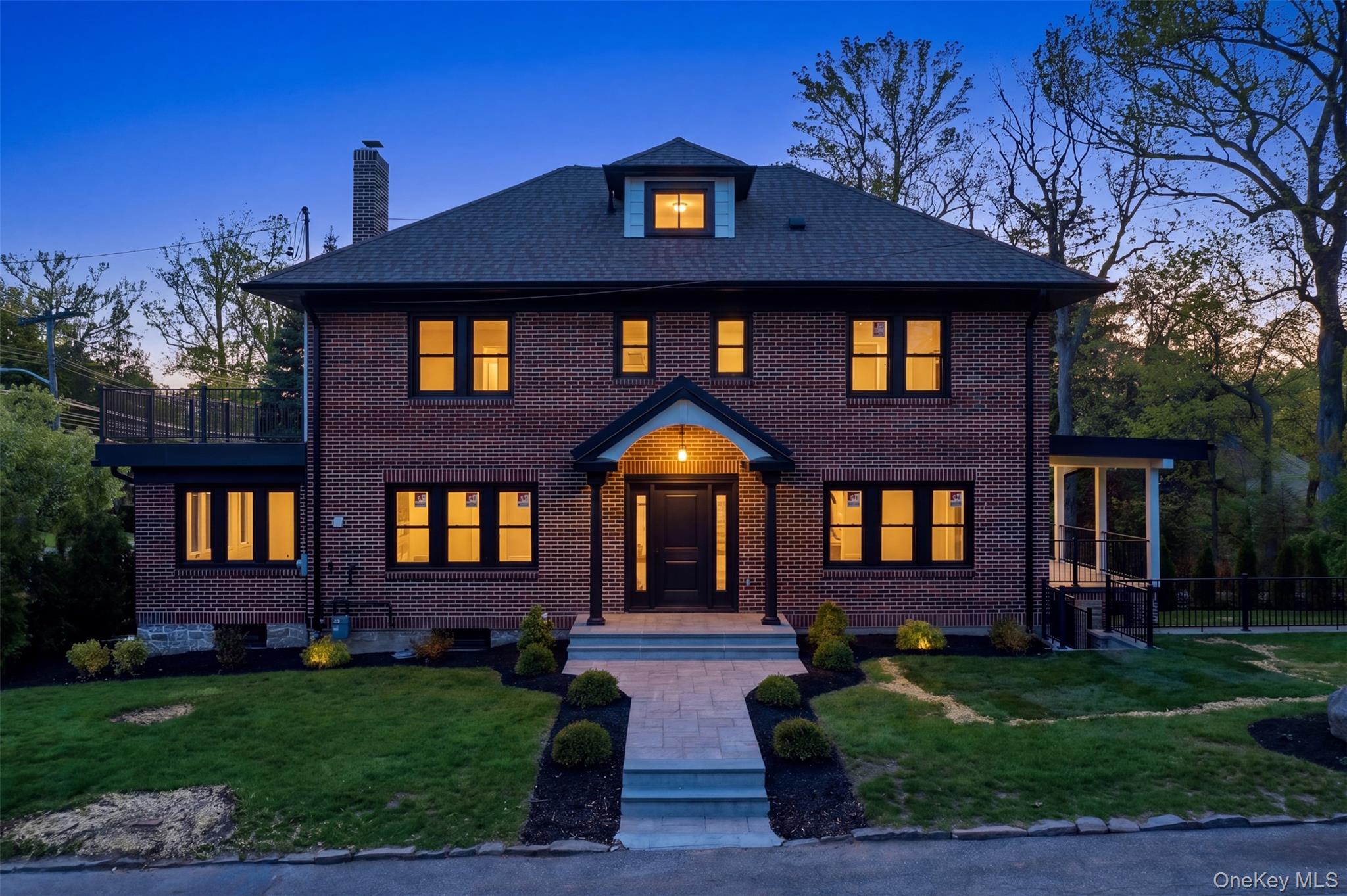 40 Calhoun Avenue New Rochelle, NY 10801 - Photo 45 of 49 Brick facade residence featuring a covered entry porch, a second-story balcony with metal railing, and an enclosed side porch