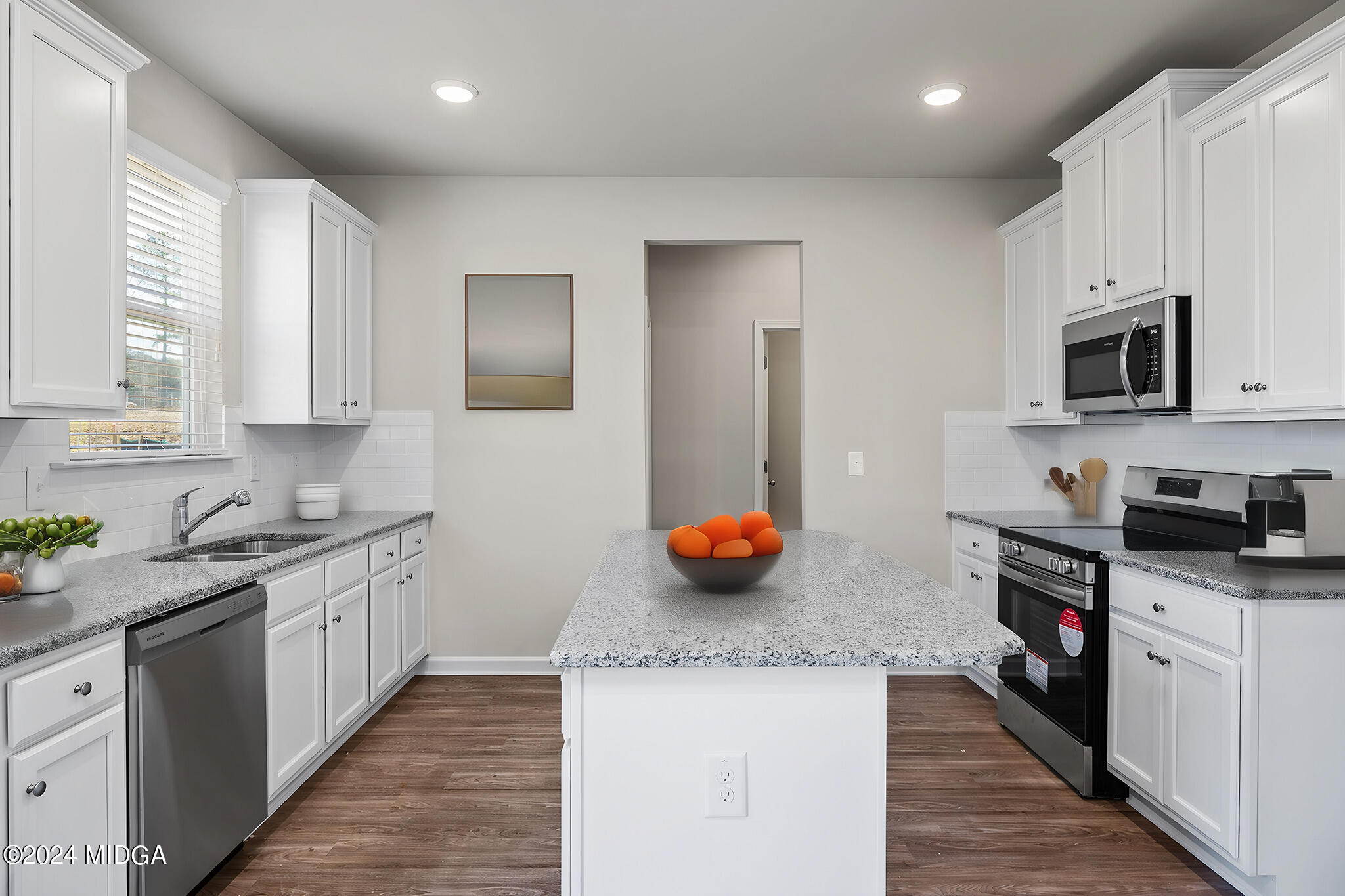 499 Grand Magnolia Street Jackson, GA 30233 - Photo 12 of 35 a kitchen with stainless steel appliances granite countertop a sink and dishwasher a stove top oven with wooden floor