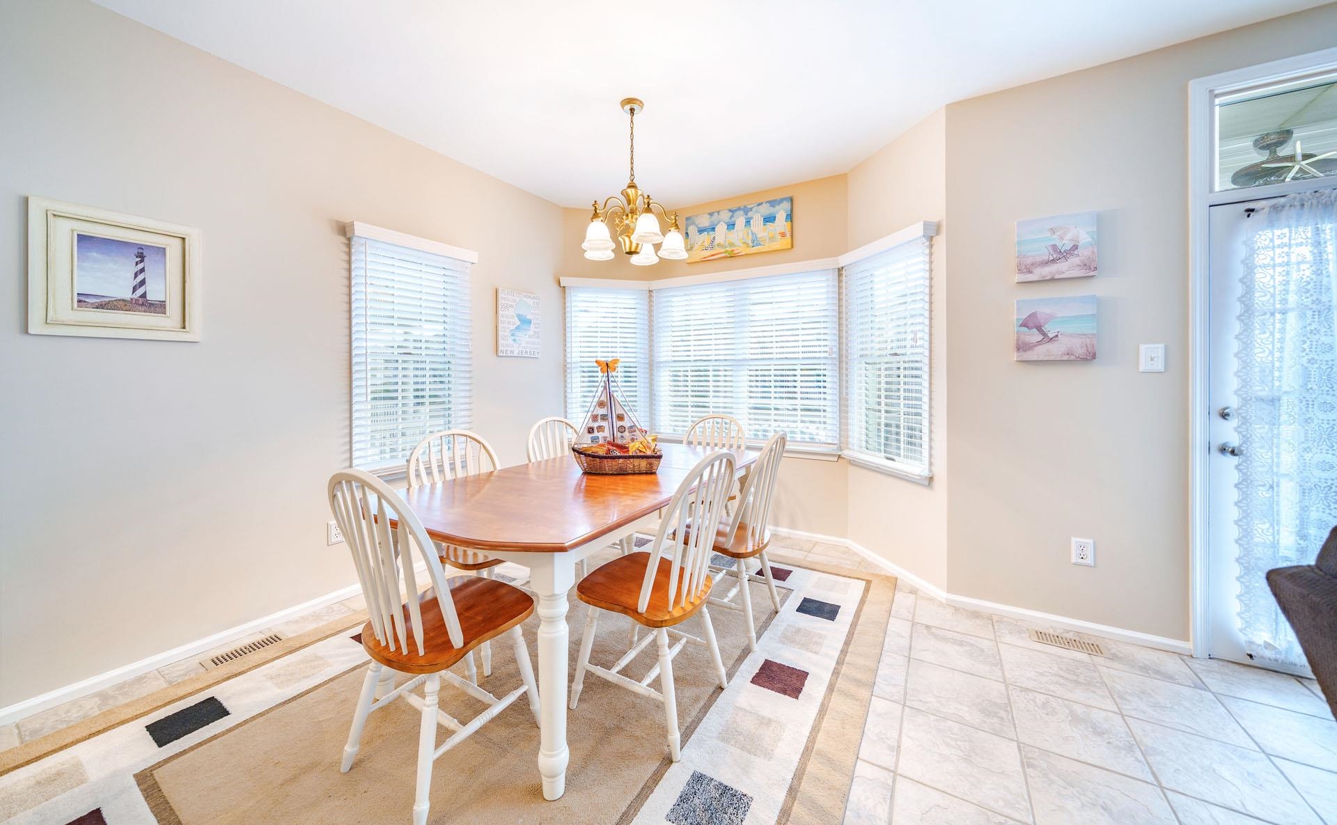 3824 Asbury Avenue, Unit 1 Ocean City, NJ 08226 - Photo 7 of 40 a view of a dining room with furniture wooden floor and a chandelier