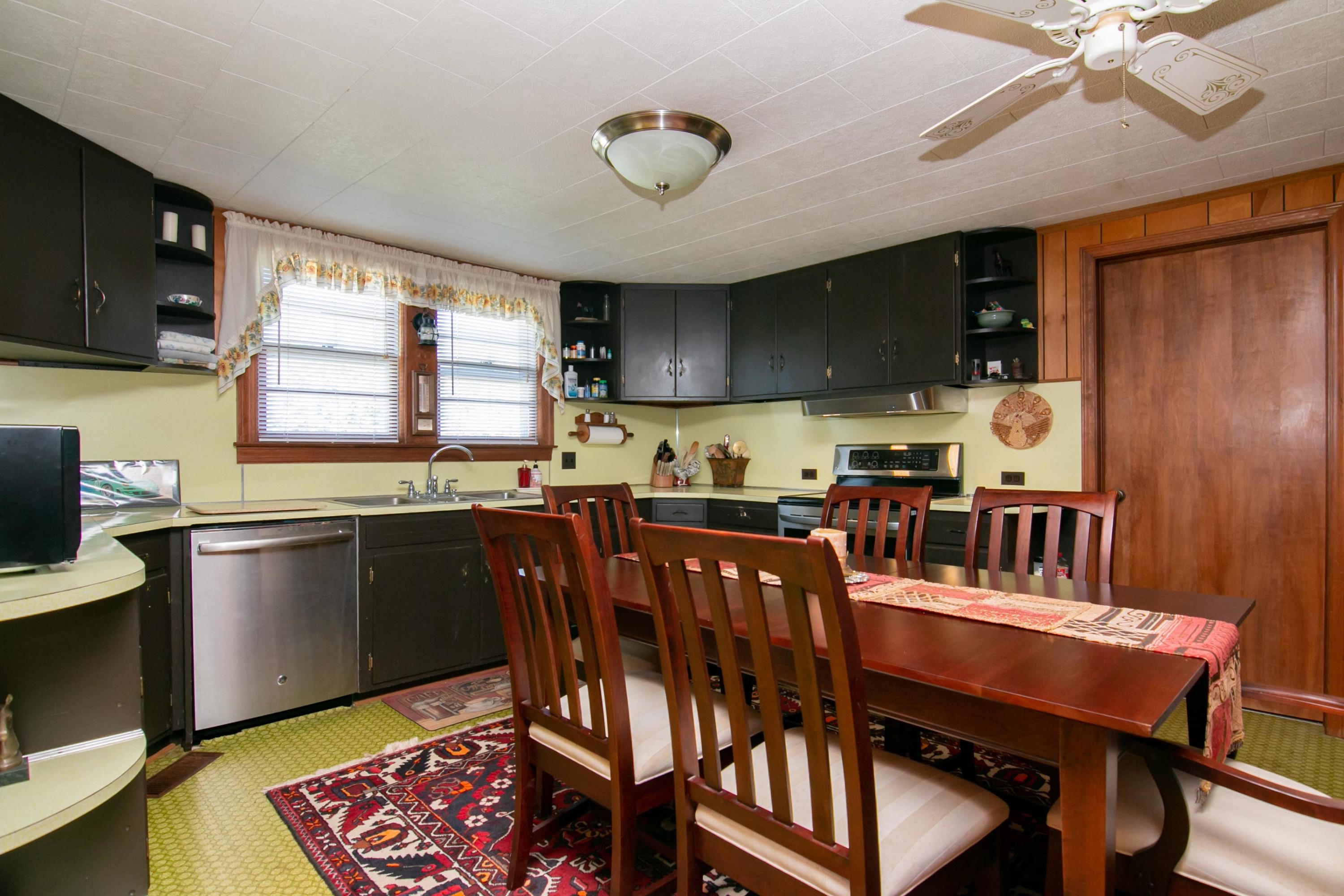 3257 Sago Road Chatham, VA 24531 - Photo 32 of 94 a kitchen with stainless steel appliances granite countertop a stove a sink dishwasher a dining table and chairs with wooden floor