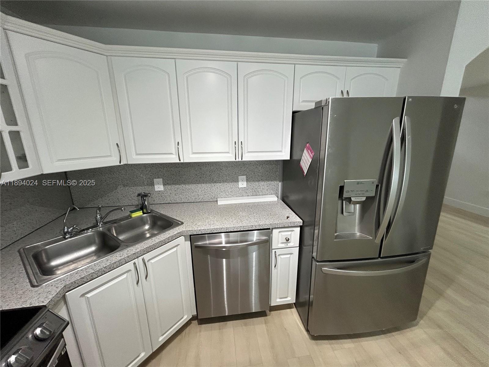 8725 Southwest 158th Place Miami, FL 33193 - Photo 16 of 53 a kitchen with a refrigerator sink and cabinets