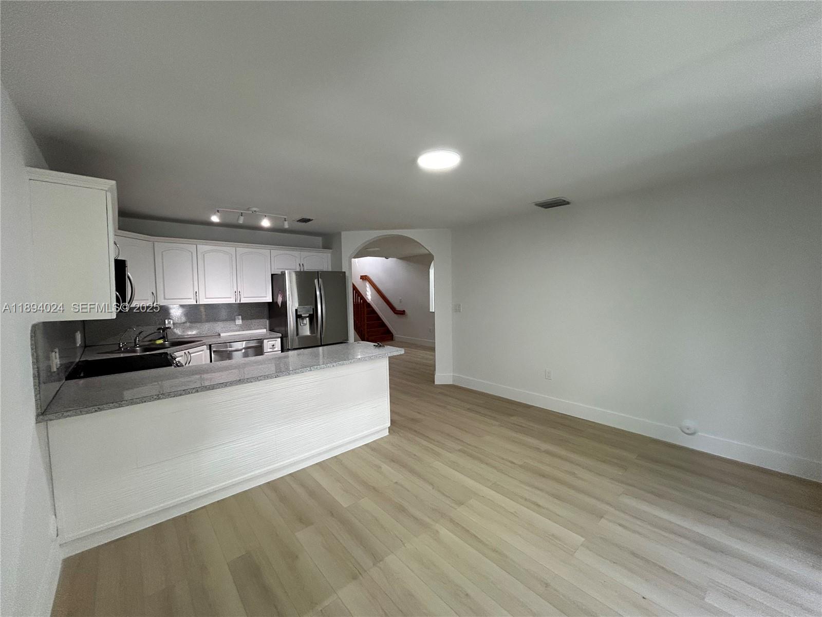 8725 Southwest 158th Place Miami, FL 33193 - Photo 17 of 53 a large kitchen with stainless steel appliances a large counter top a stove and a refrigerator