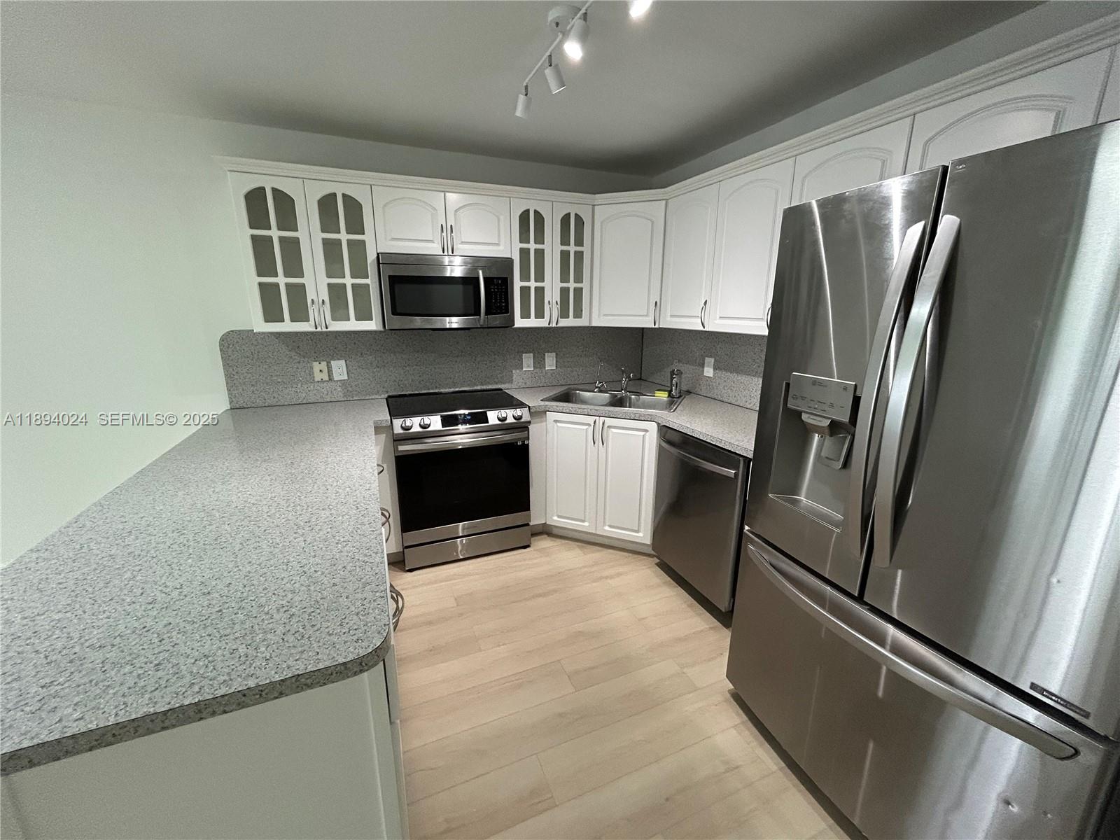 8725 Southwest 158th Place Miami, FL 33193 - Photo 18 of 53 a kitchen with stainless steel appliances granite countertop a refrigerator stove top oven and sink