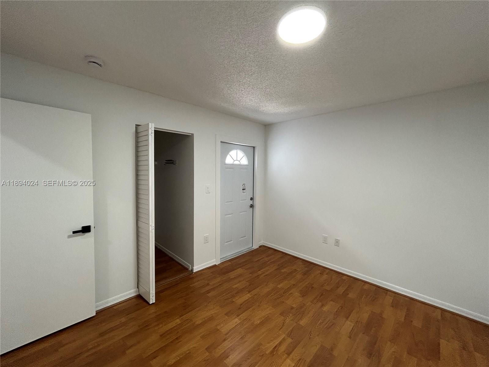 8725 Southwest 158th Place Miami, FL 33193 - Photo 27 of 53 an empty room with wooden floor and windows