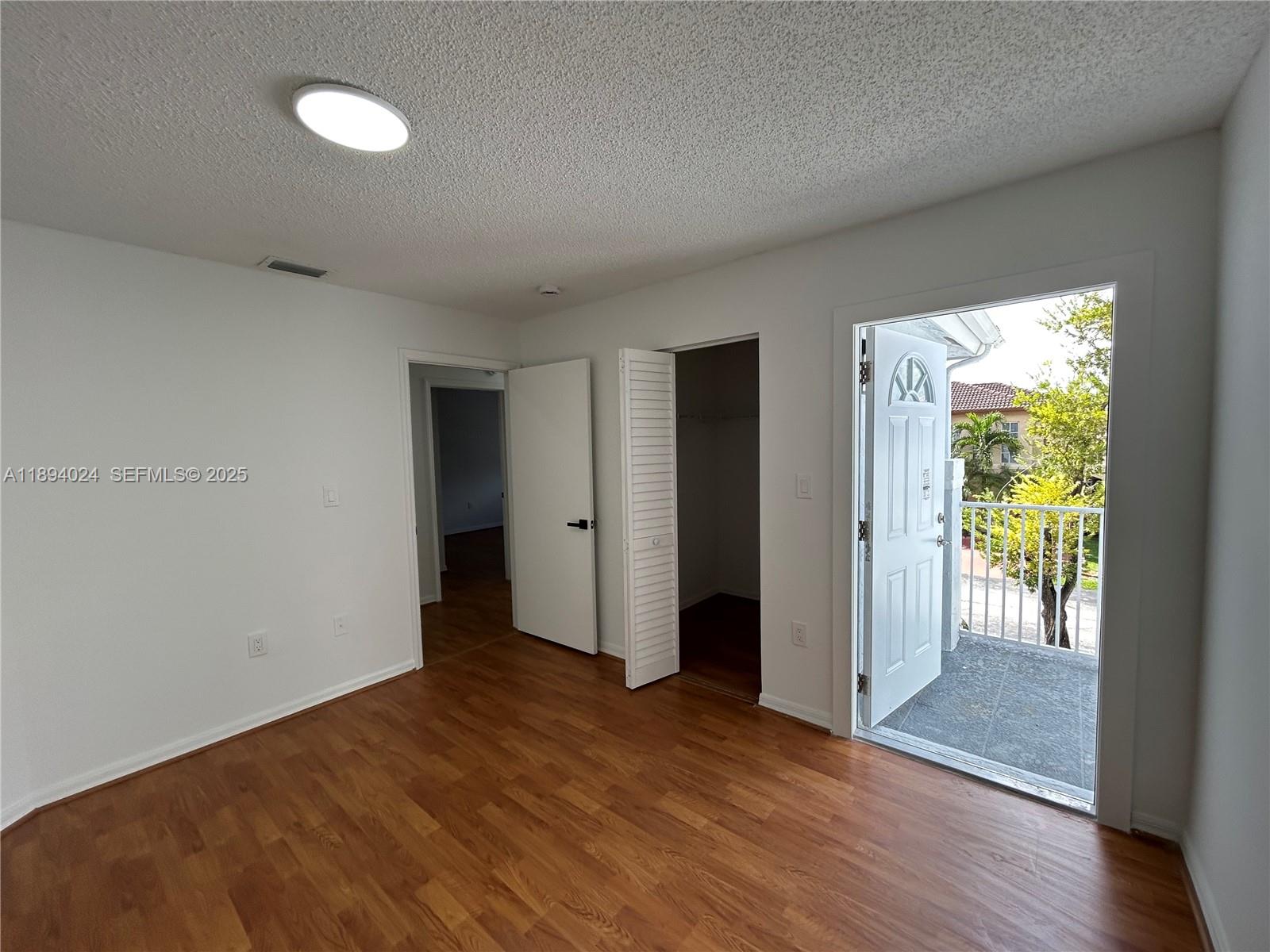 8725 Southwest 158th Place Miami, FL 33193 - Photo 29 of 53 a view of an empty room with a window and wooden floor