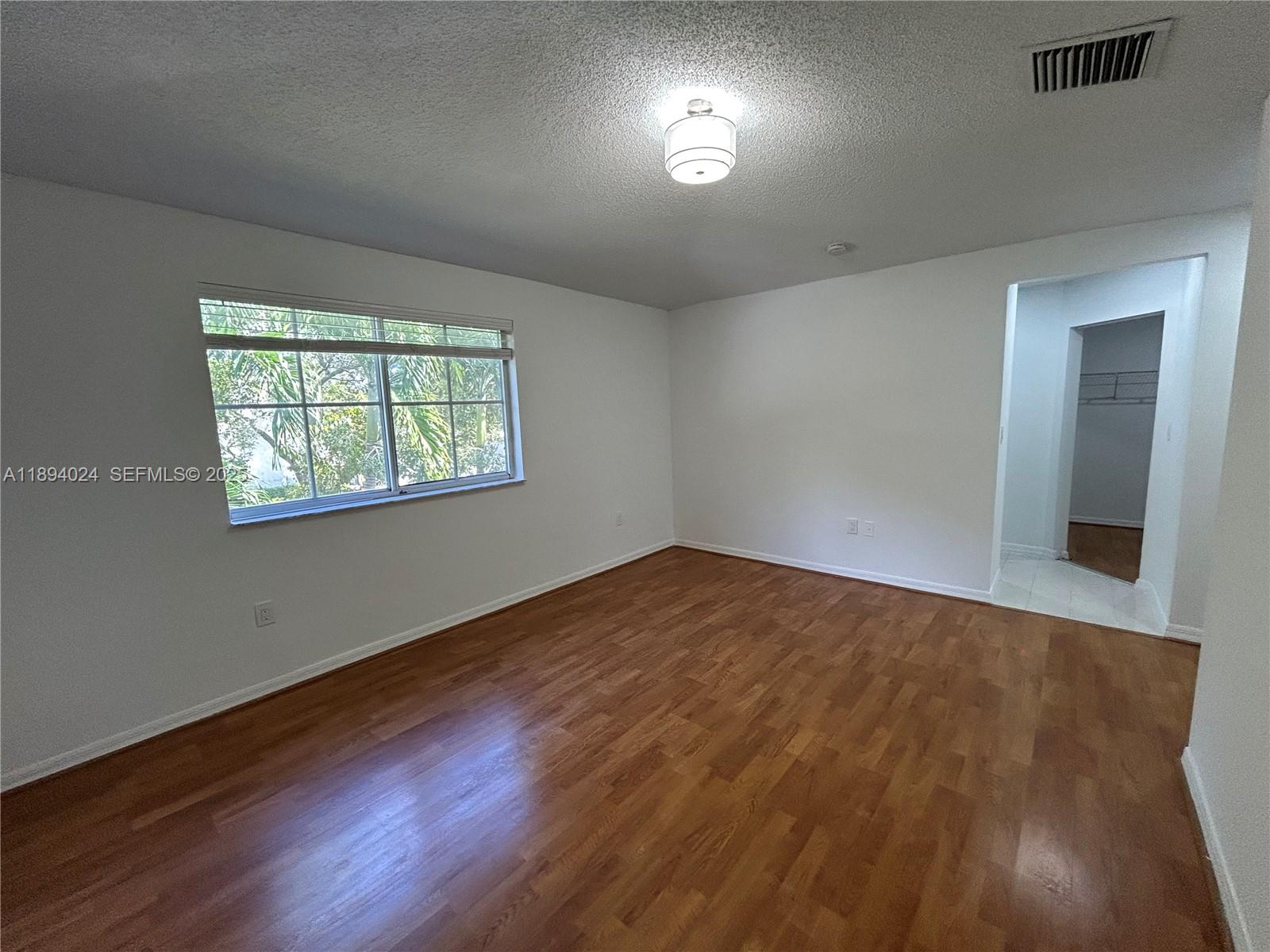 8725 Southwest 158th Place Miami, FL 33193 - Photo 37 of 53 a view of an empty room with wooden floor and a window