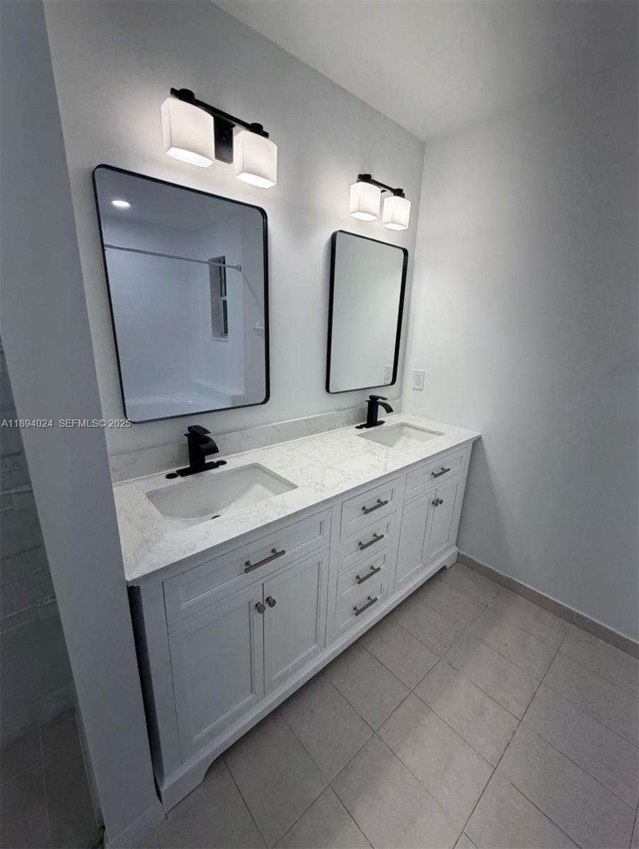 8725 Southwest 158th Place Miami, FL 33193 - Photo 44 of 53 a bathroom with a double vanity sink and mirror