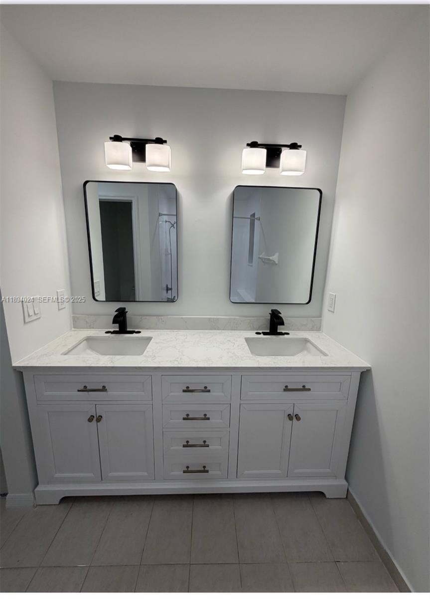 8725 Southwest 158th Place Miami, FL 33193 - Photo 45 of 53 a bathroom with a double vanity sink and mirror