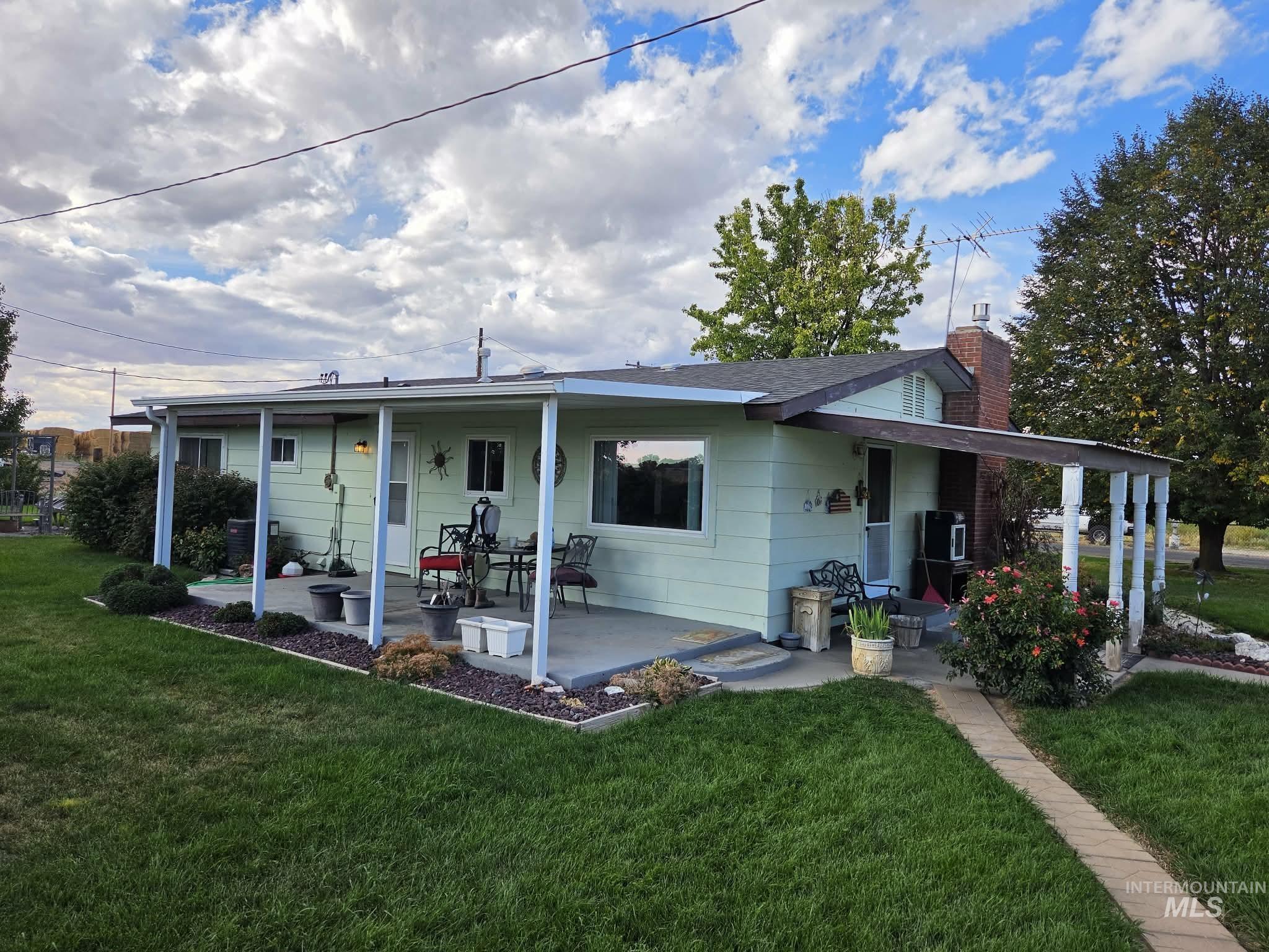 1535 Sunnyside Road Weiser, ID 83672 - Photo 21 of 26 Expansive covered patio, brick chimney, established landscaping, and a paver pathway