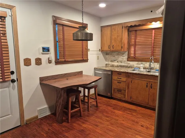 a kitchen with kitchen island a dining table chairs and wooden floor