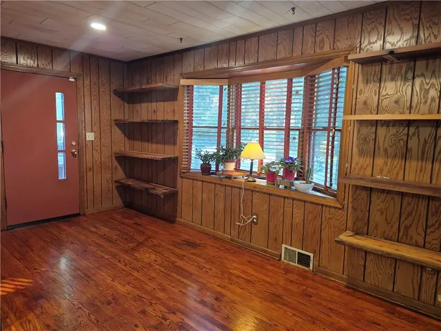 a kitchen with stainless steel appliances kitchen island granite countertop a refrigerator a stove and a wooden floors