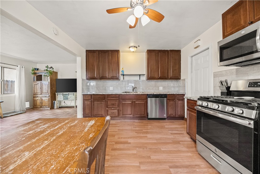 680 North 10th Street Banning, CA 92220 - Photo 7 of 24 a kitchen with stainless steel appliances granite countertop a stove a sink and a microwave