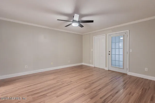 a view of an empty room with wooden floor
