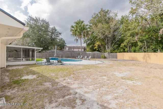 a view of a house with backyard and a tree