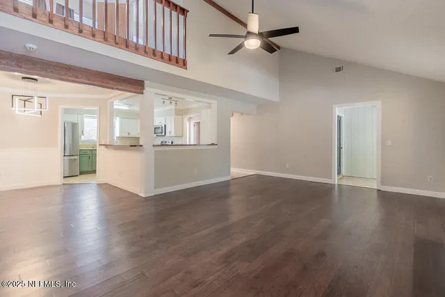 a view of a hallway with wooden floor and a living room