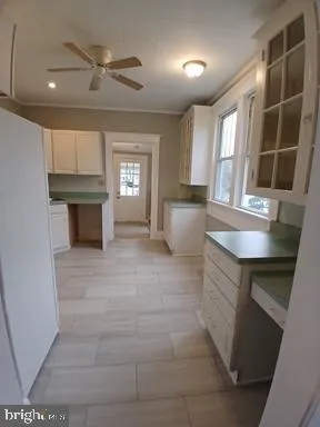 a view of kitchen with cabinets and window