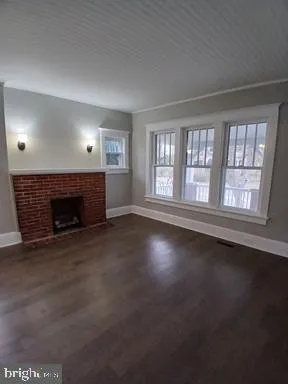 an empty room with windows and fireplace