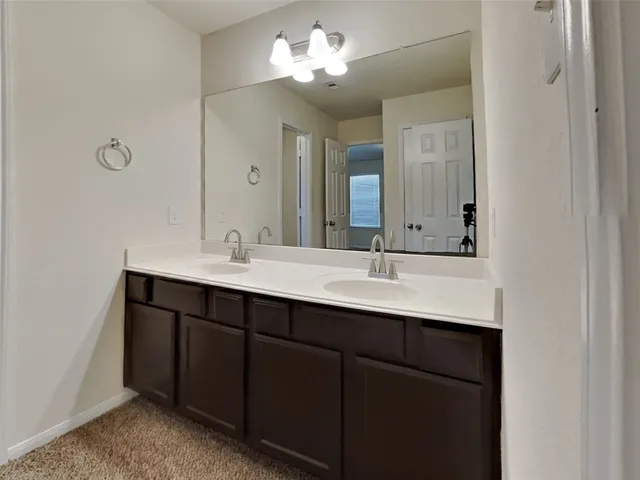 a bathroom with double vanity sink and a mirror