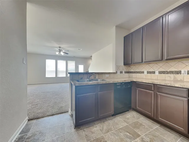 a kitchen with granite countertop a sink and cabinets