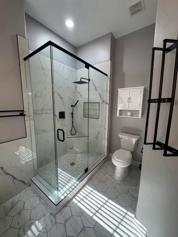 a bathroom with a toilet and a shower